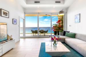 a living room with a couch and a view of the ocean at Lighthouse Point Residences in West Bay