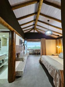 a bedroom with a large bed and a dining room at Studio Moderno com Vista pro mar com hidromassagem e churrasqueira privativas e Piscina aquecida na área comum in São Sebastião +47 photos