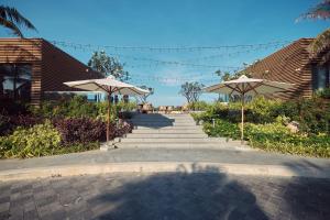 a walkway with two umbrellas and a staircase at Sunrise Pool Villa Cam Ranh in Cam Ranh