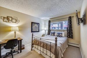 a bedroom with a bed and a desk and a window at Longbranch 214 in Breckenridge +25 photos
