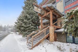 a building with a wooden staircase in the snow at Longbranch 214 in Breckenridge