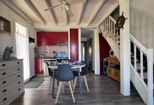 a kitchen with a table and chairs and a staircase at 4HTAMA5-Charmante maisonnette avec terrasse in Le Barcarès