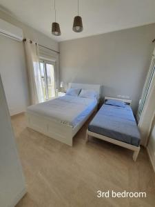 a bedroom with two beds and a window at Almaza bay Beach Town Chalet in Marsa Matruh