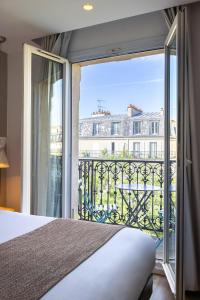 a bedroom with a bed and a large window at Hotel Magenta 38 by Happyculture in Paris +61 photos