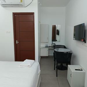 a bedroom with a bed and a table and a desk at Hotel Eleven Space Kochi in Cochin