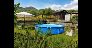 a blue tub in a yard with an umbrella at Il Posto delle Rose 1 in San Polo dei Cavalieri