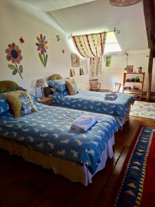 a bedroom with two beds with blue sheets on them at Country Farmhouse with pool in Lascazères