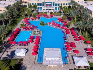 an overhead view of a resort swimming pool with red umbrellas at Rixos Sharm El Sheikh - Adults Only 18 Plus in Sharm El Sheikh
