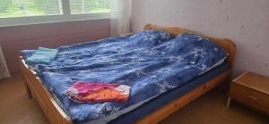 an unmade bed with a blue comforter on it at Pankkikallio 8 in Sorsakoski