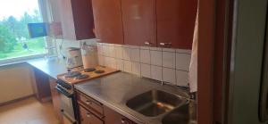 a kitchen with a sink and a stove top oven at Pankkikallio 8 in Sorsakoski