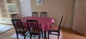 a dining room table with four chairs and a purple table cloth at Pankkikallio 8 in Sorsakoski