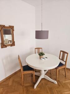 a white dining room table with two chairs and a mirror at City Apartment in Bad Arolsen