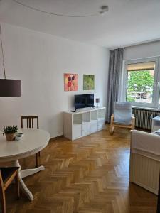 a living room with a couch and a table and a tv at City Apartment in Bad Arolsen