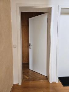 an open white door in a room with wooden floors at City Apartment in Bad Arolsen