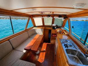 a boat with a bench and a sink in the middle at Che Manovra - A Night Onboard! in Porto San Paolo