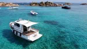 a white boat in the water in the ocean at Che Manovra - A Night Onboard! in Porto San Paolo