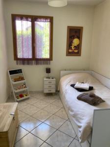 a bedroom with a bed and a table and windows at L'Esperluette in Thyez