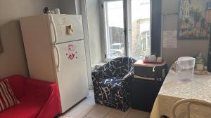 a kitchen with a refrigerator and a chair and a table at Auberge St-Louis in Quebec City