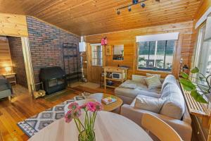 ein Wohnzimmer mit Sofa und Kamin in der Unterkunft Whispering Woods Cabin in Porvoo