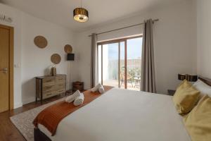 a bedroom with a large white bed and a window at Vila Moleza in Vau