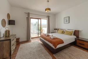 a bedroom with a bed and a large window at Vila Moleza in Vau