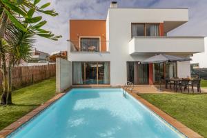 a villa with a swimming pool in front of a house at Vila Moleza in Vau