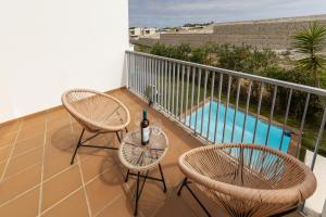 a balcony with two chairs and a bottle of wine at Vila Moleza in Vau +19 photos