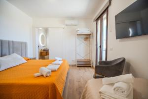 a bedroom with two beds and a chair and a television at Tenuta Bruni - Agriturismo & Pool in Squinzano