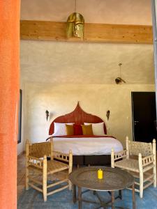 a bedroom with a bed with two chairs and a table at Domaine Coul'Eau in Eaunes
