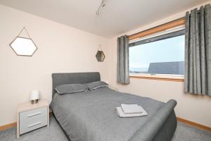 a bedroom with a bed and a large window at Soundview in Lerwick