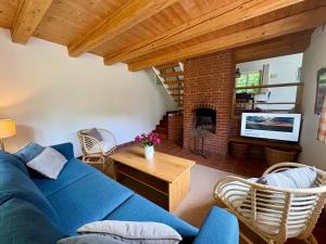 a living room with a blue couch and a fireplace at Haus Ahrens in Braderup