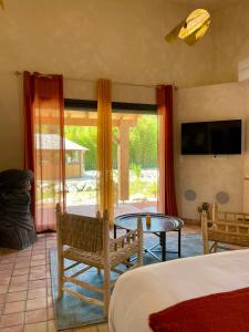 a bedroom with a bed and a table and chairs at Domaine Coul'Eau in Eaunes