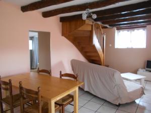 a dining room with a wooden table and a staircase at gite a la ferme in Milhac +3 photos