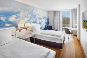 a hotel room with two beds and a window at Hey Lou Hotel Friedrichshafen in Friedrichshafen