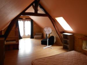 a attic room with a bed and a staircase at gite a la ferme in Milhac