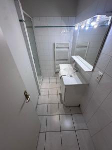 a white bathroom with a sink and a mirror at Le Perchoir in Chalon-sur-Saône