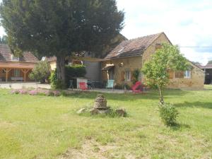 a house with a yard with a tree and a stump at gite a la ferme in Milhac