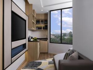 a living room with a large flat screen tv at Novotel Rayong Star Convention Centre in Rayong +81 photos