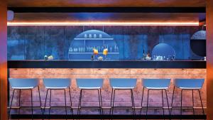 a row of blue chairs in front of a bar at Hey Lou Hotel Nördlingen in Nördlingen
