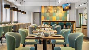 a dining room with wooden tables and chairs at Hey Lou Hotel Karlsruhe Messe in Karlsruhe