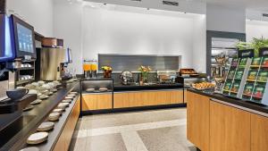 a restaurant kitchen with a counter with food at Hey Lou Hotel Karlsruhe Messe in Karlsruhe