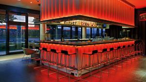 a red bar with red chairs in a restaurant at Hey Lou Hotel Monheim am Rhein in Monheim