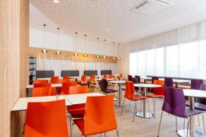a dining room with tables and colorful chairs at Hey Lou Hotel Hildesheim in Hildesheim +18 photos