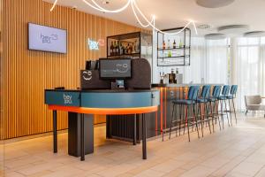 a bar in a restaurant with a counter and chairs at Hey Lou Hotel Hildesheim in Hildesheim