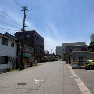 an empty street in a city with buildings at ゲストハウスヤドカリ in Nanao