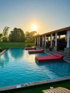 a swimming pool with red pillows in the water at Eco Hotel La Colina Mirador Con aire acondicionado in Quimbaya