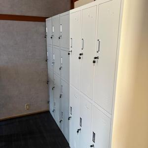 a locker room with white lockers in a room at ゲストハウスヤドカリ in Nanao