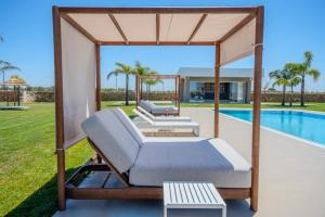 a gazebo with two beds and a pool at Tenuta Bruni - Agriturismo & Pool in Squinzano