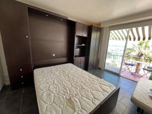 a bedroom with a bed with a view of a patio at Studio Bandol Port in Bandol