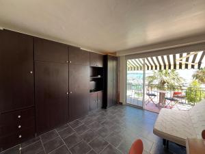 a kitchen with brown cabinets and a view of a patio at Studio Bandol Port in Bandol